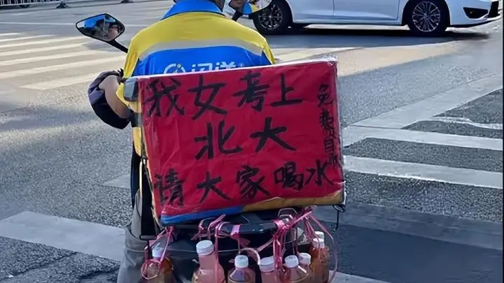 8月2日南宁闪送员电动车挂满饮品邀路人共贺 平台承诺承担其女儿北大录取学费